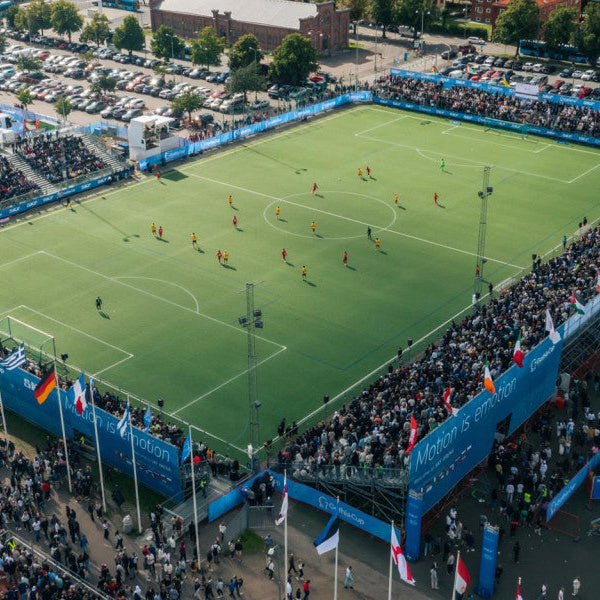 Soccer match in progress at a stadium with spectators and flags